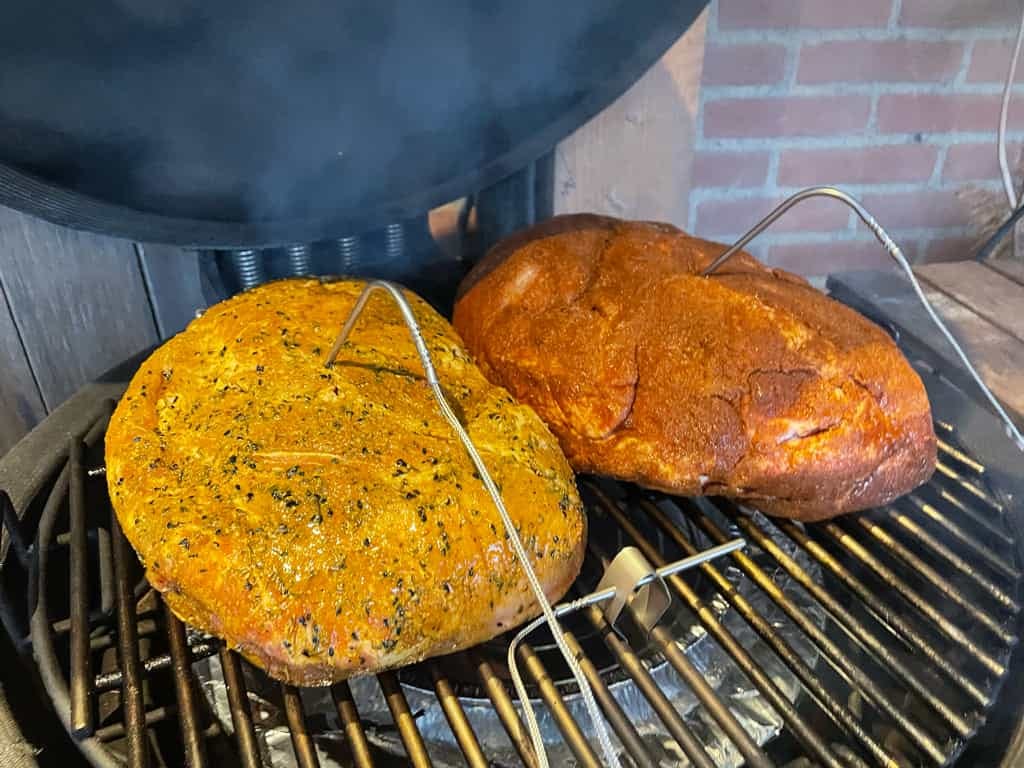 Twee stukken procureur op een barbecue met daarin de temperatuur voelers van de controller en een temperatuur voeler van de controller op het rooster gemonteerd