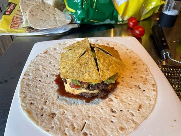 burgers op een wrap met cheddar, guacamole en tortilla chips